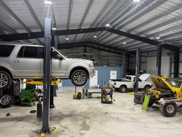 SUV raised on a vehicle lift inside the Atlas Automotive shop