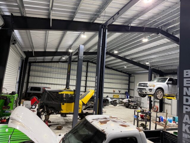 Wide view of the Atlas Automotive repair facility with vehicles in service bays