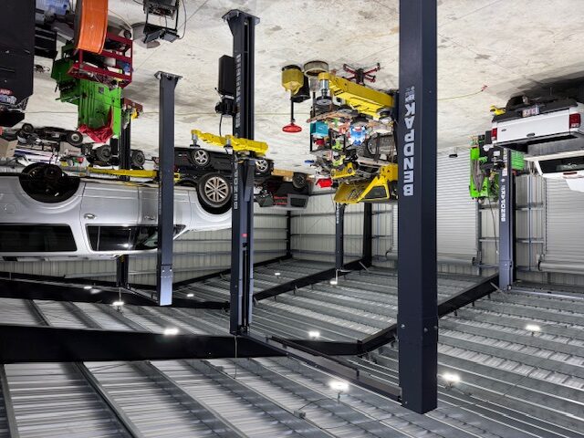Atlas Automotive repair bays in Naples, FL with BendPak two-post lifts and an SUV raised for service